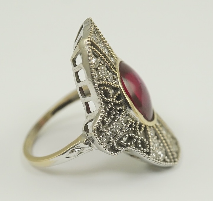 A gold, cabochon ruby and diamond cluster set upfinger ring